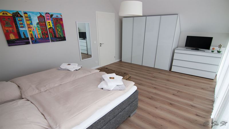 Helles Schlafzimmer mit Doppelbett und Kleiderschrank