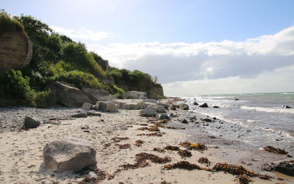 Steilküste mit Steinen am Strand