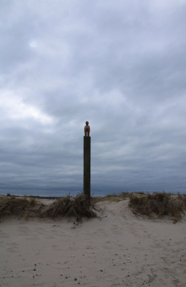 Strand mit Turm unter bewölktem Himmel