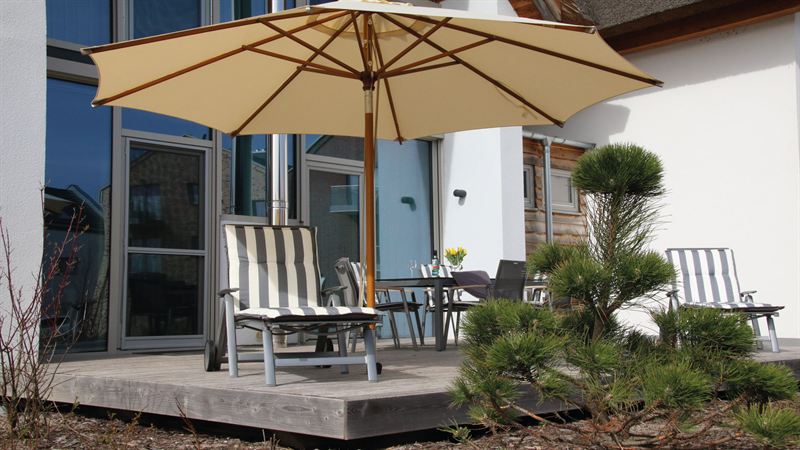 Terrasse mit Sonnenschirm und Stühlen